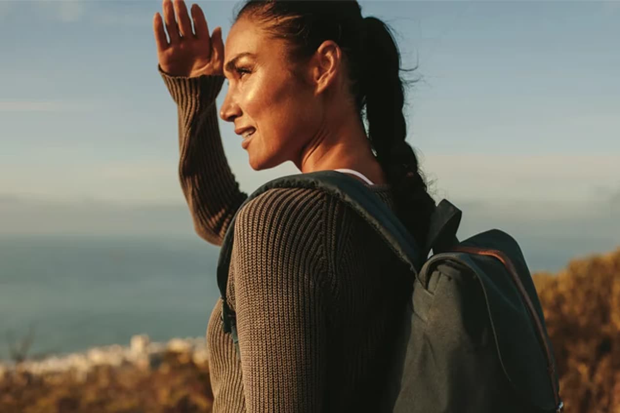  A woman standing atop mountain heights, gazing at the landscape—crafted for explorers, built for elegance.
